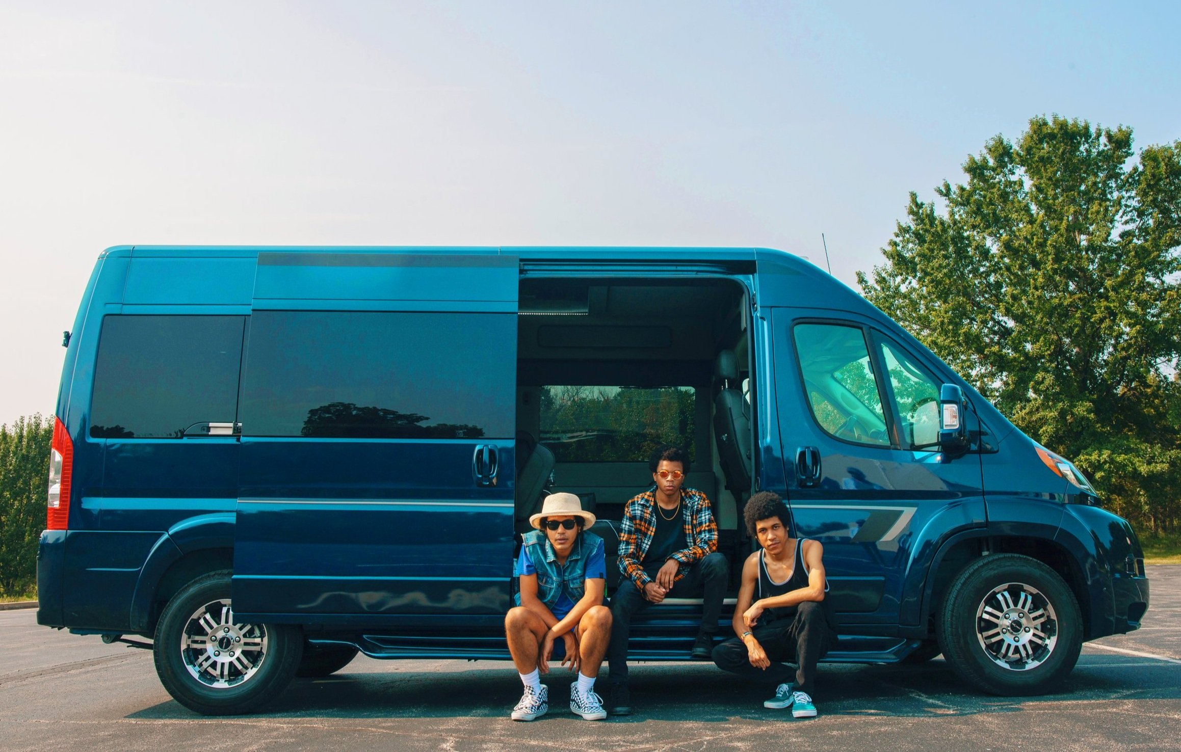 Band sits beside a Ram van.