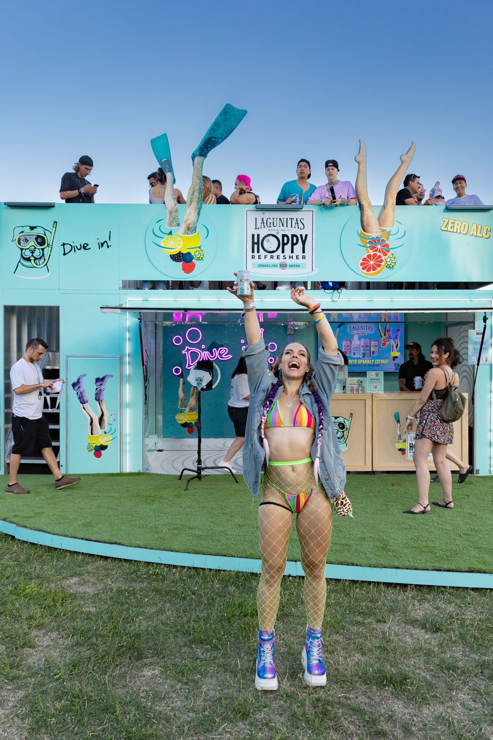 A girl holds a Lagunitas Hoppy Refresher above her head at a pop-up event.