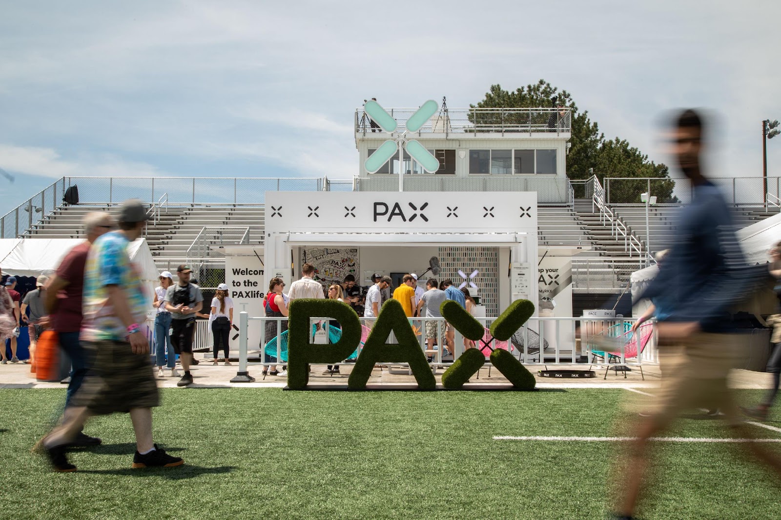 Attendants walk around the field at the PAX Labs pop-up.