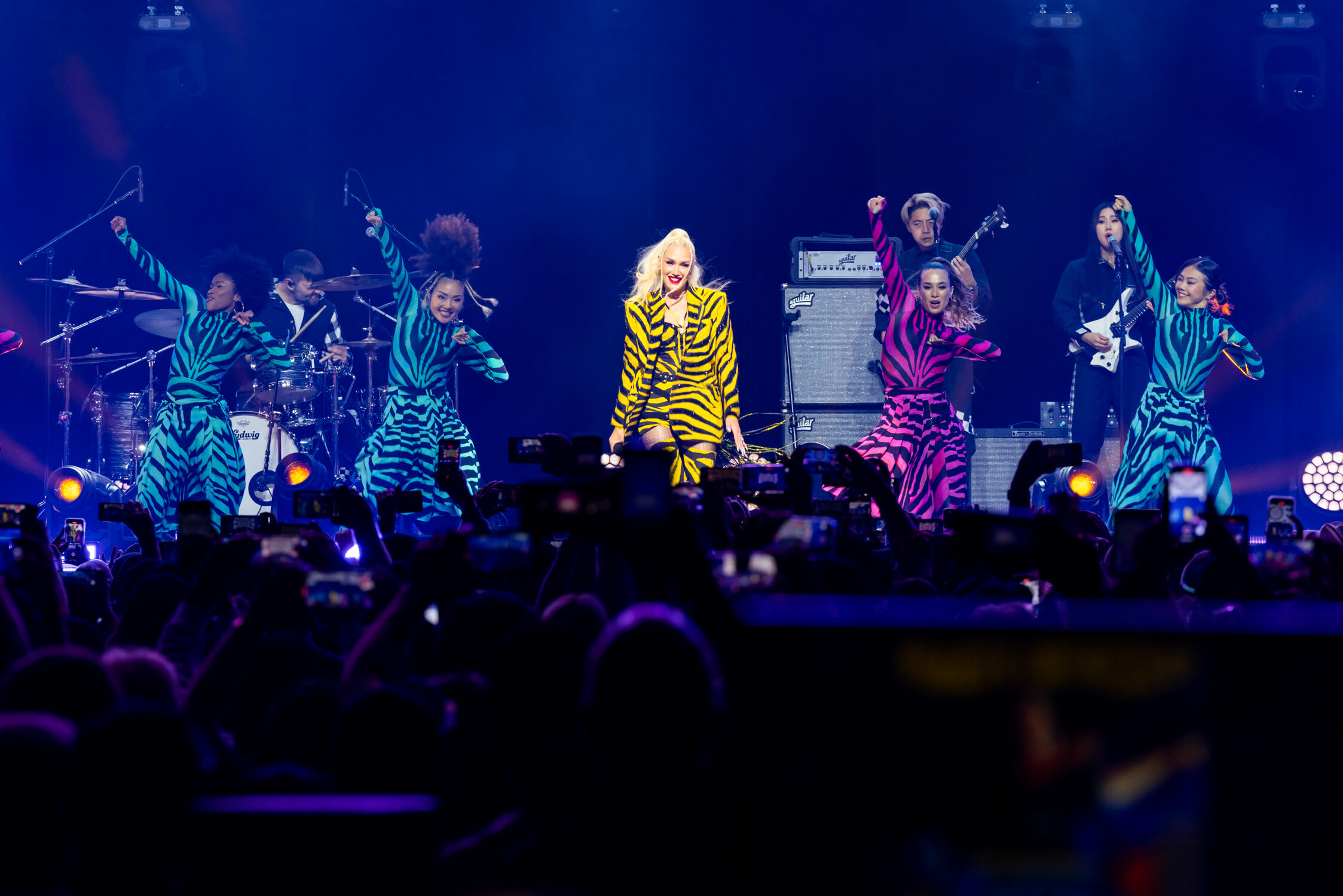 Gwen Stefani performs, surrounded by dancers wearing neon zebra print, as part of Cisco Live 2023.