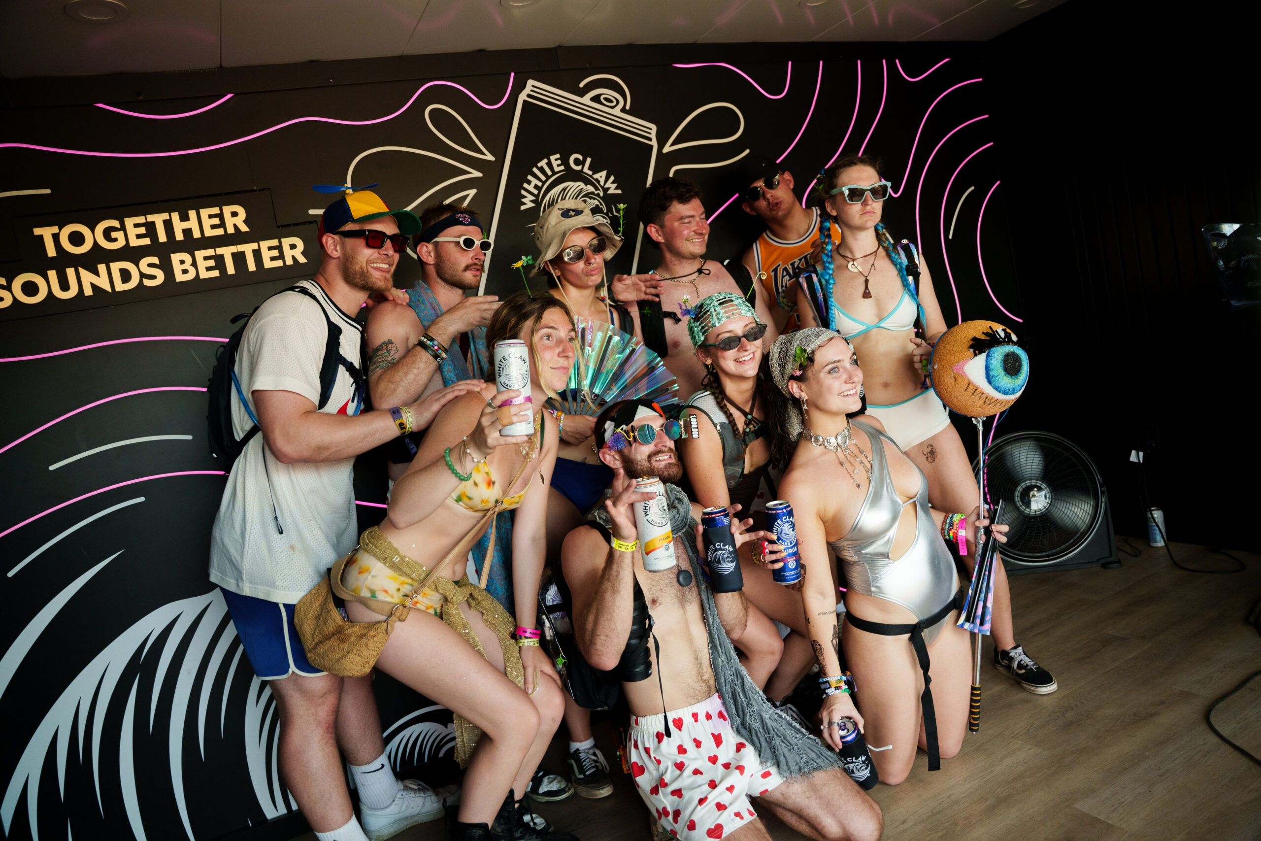 Group posing in White Claw activation photo op at a festival environment